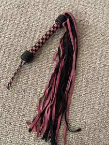 Pink and black leather whip